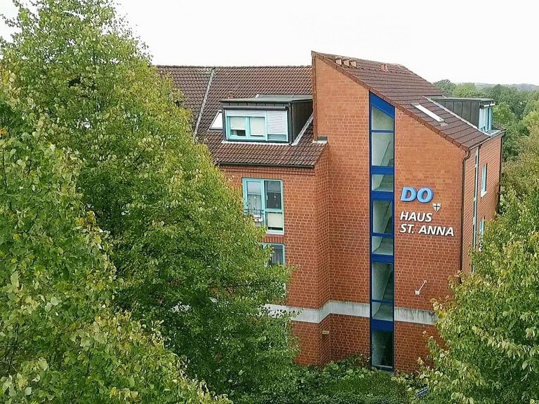 Aussenansicht: DO - Haus St. Anna - Backsteingebäude mit vielen Bäumen